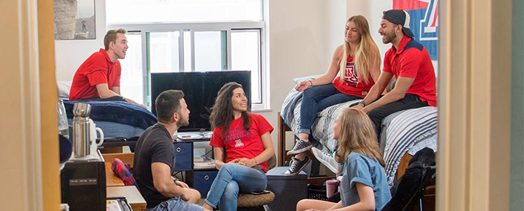 Photo of University of Arizona students in a dorm room on campus.