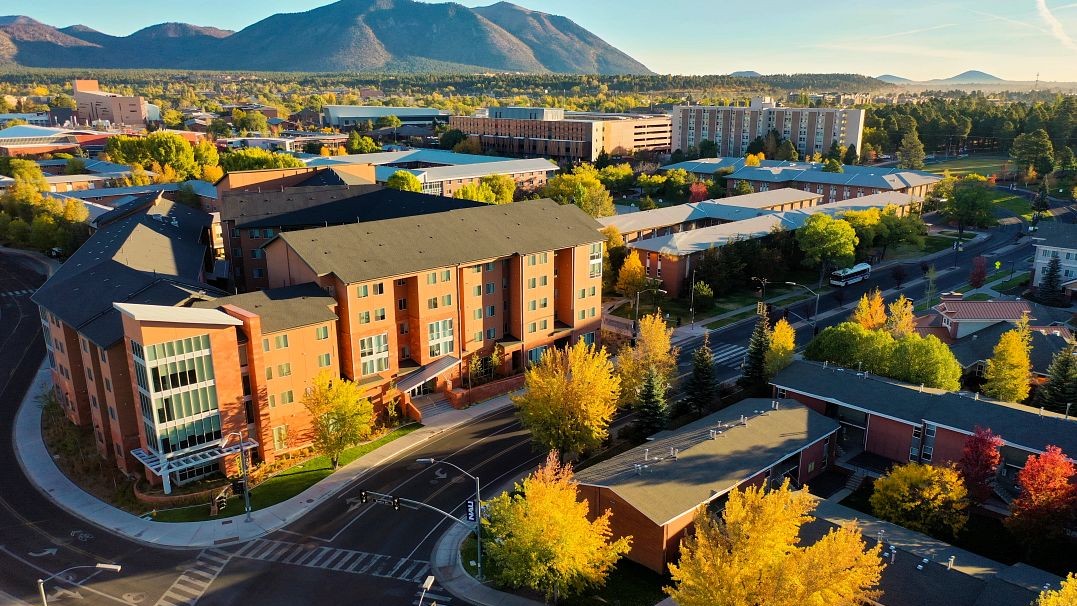 Image of the NAU campus in the fall with colorful trees and the San Francisco Peaks in the background 