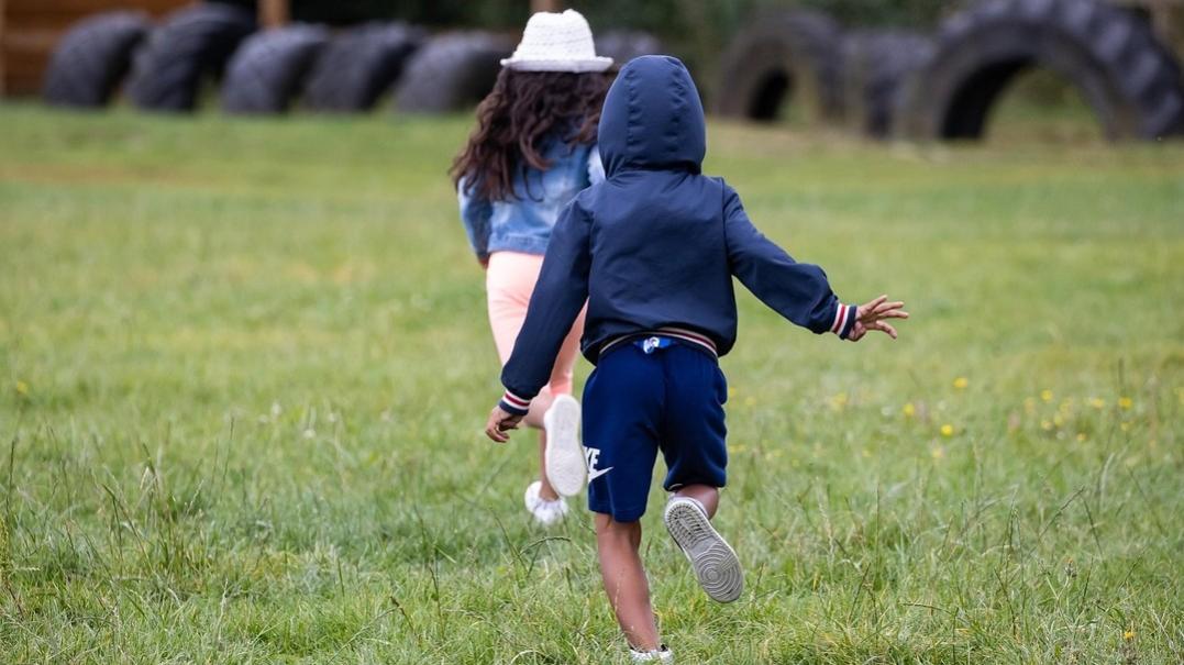 Photo of children running in grass 