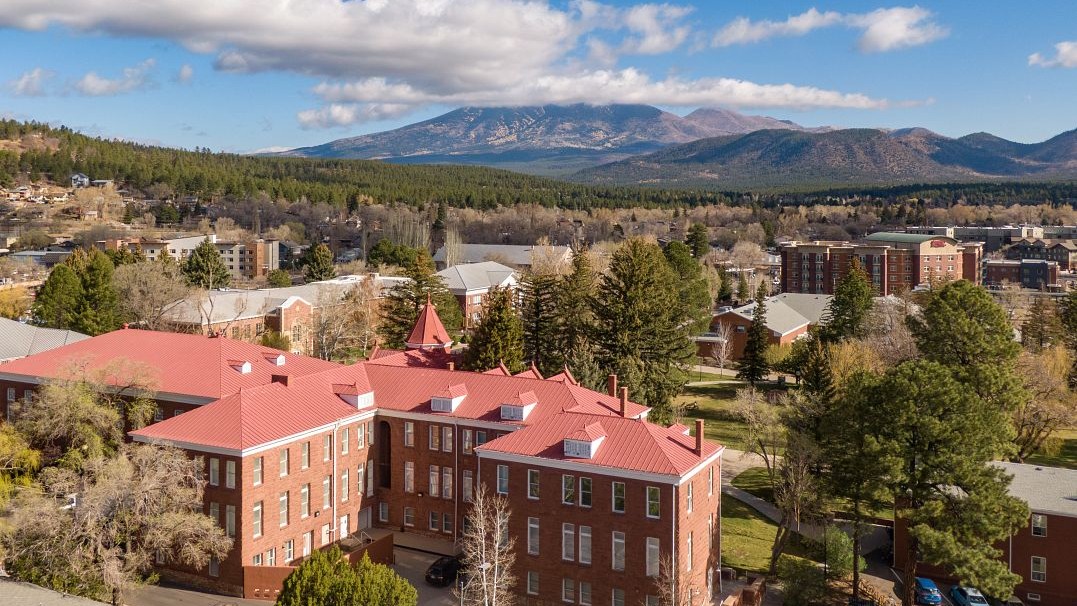 Aerial view of campus with the San Francisco Peaks and clouds in the background 