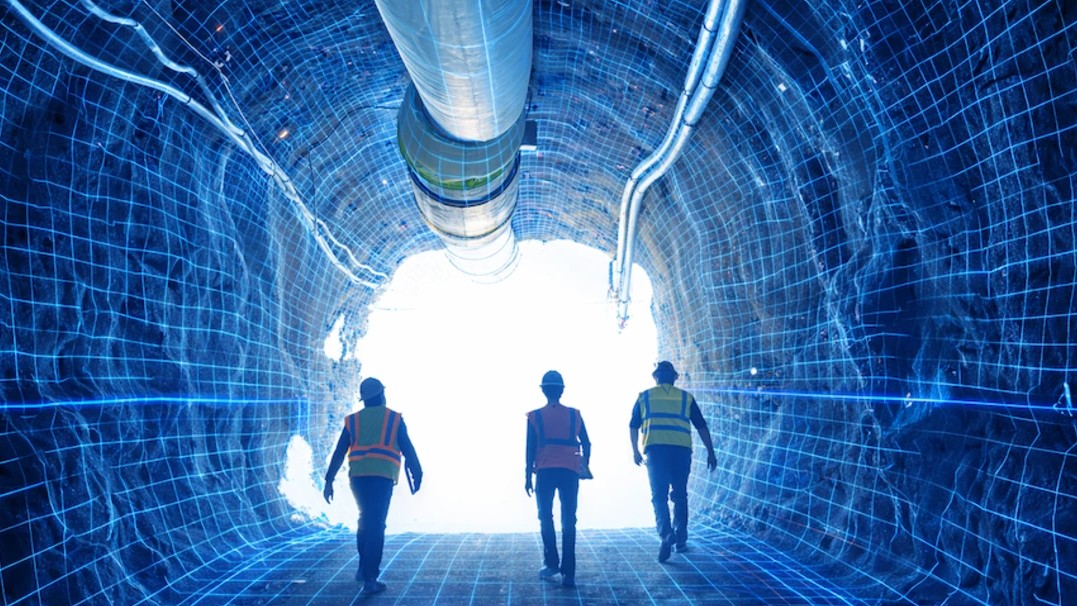 Image of three workers walking in hard hats walking in a tunnel 