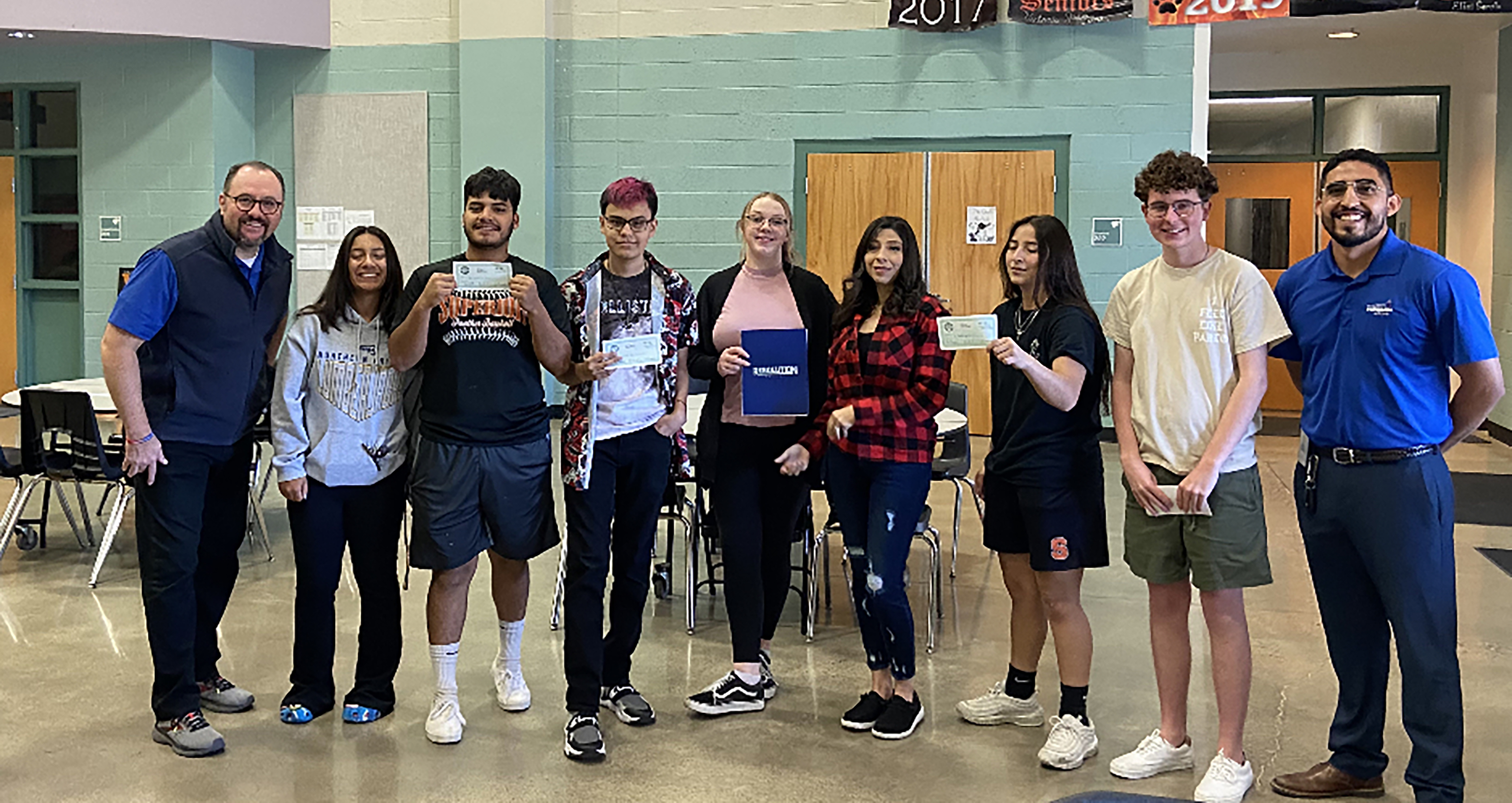 Students and advisors holding FAFSA checks