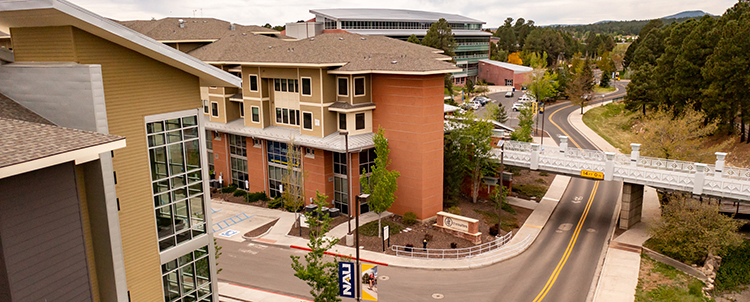 Photo of NAU campus with buildings on the right and a street on the left 