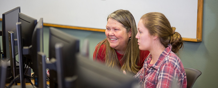 Two female students looking at computer screen. 