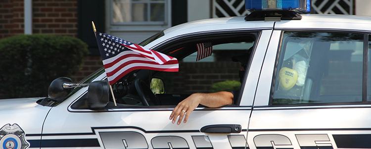 Photo of a police car and American flag.