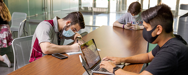 Three students at table studying